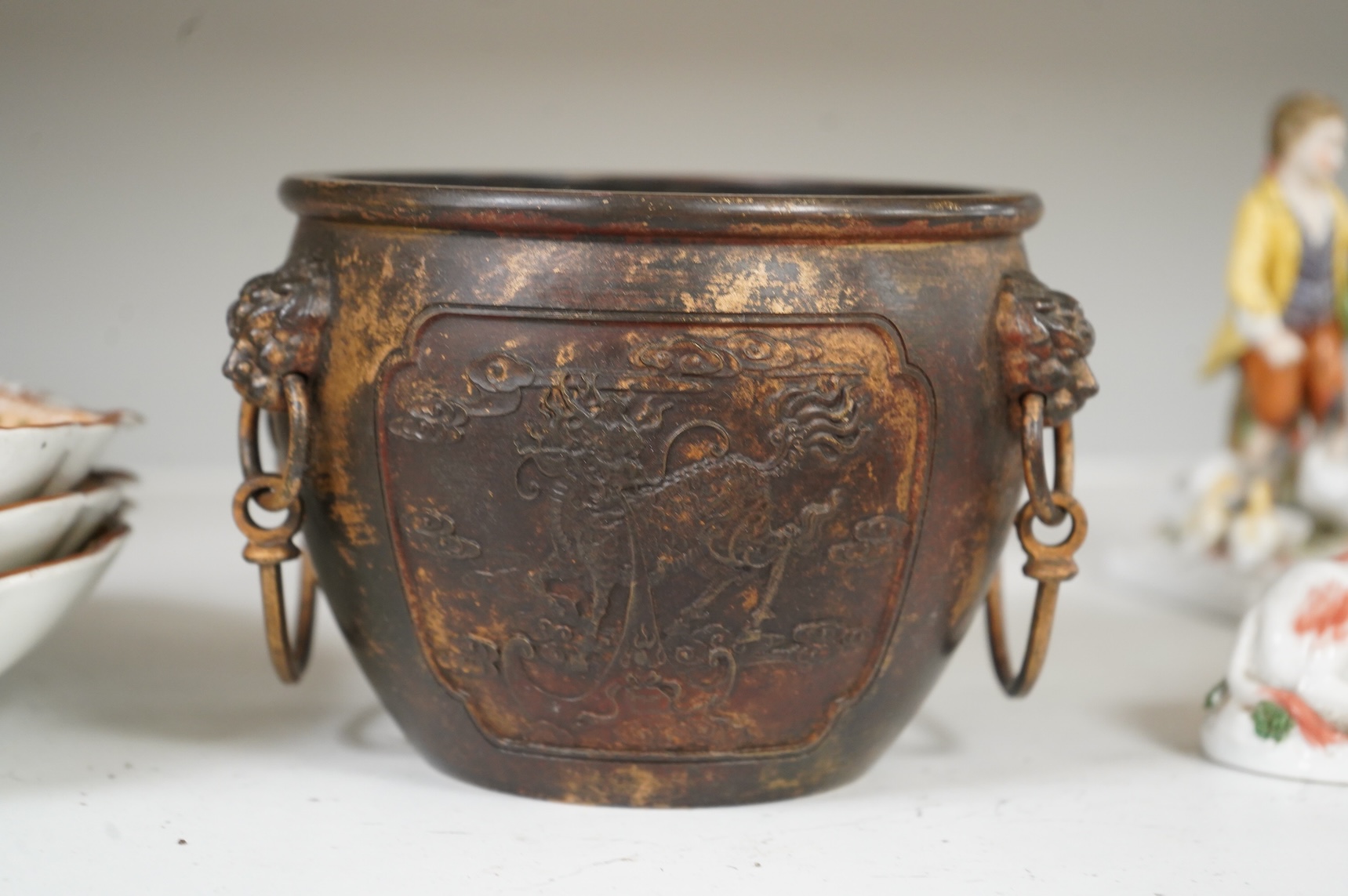 A Chinese partially gilt bronze censer, decorated in relief with twin handles, 16cm in diameter